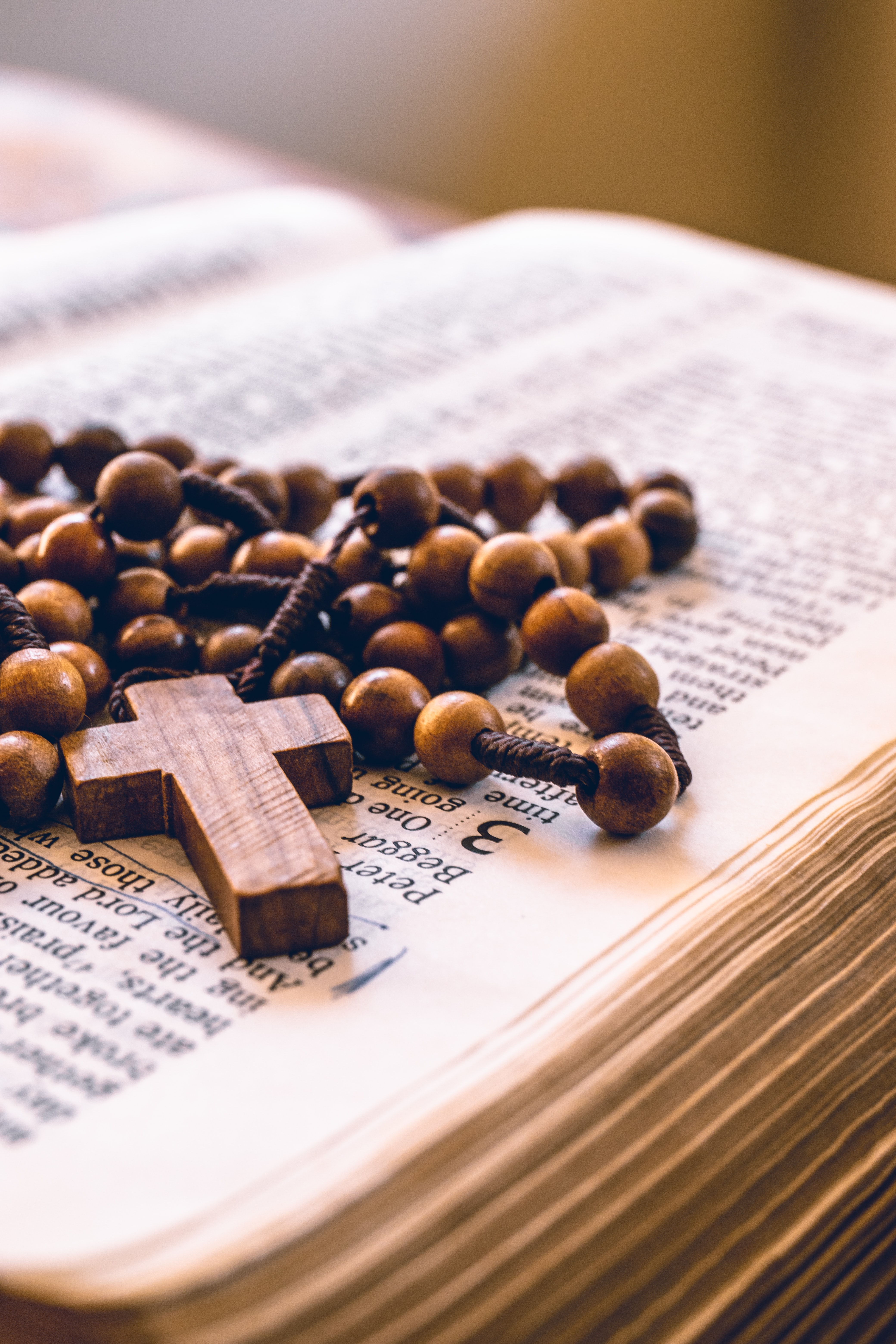 Wooden rosary on top of open bible