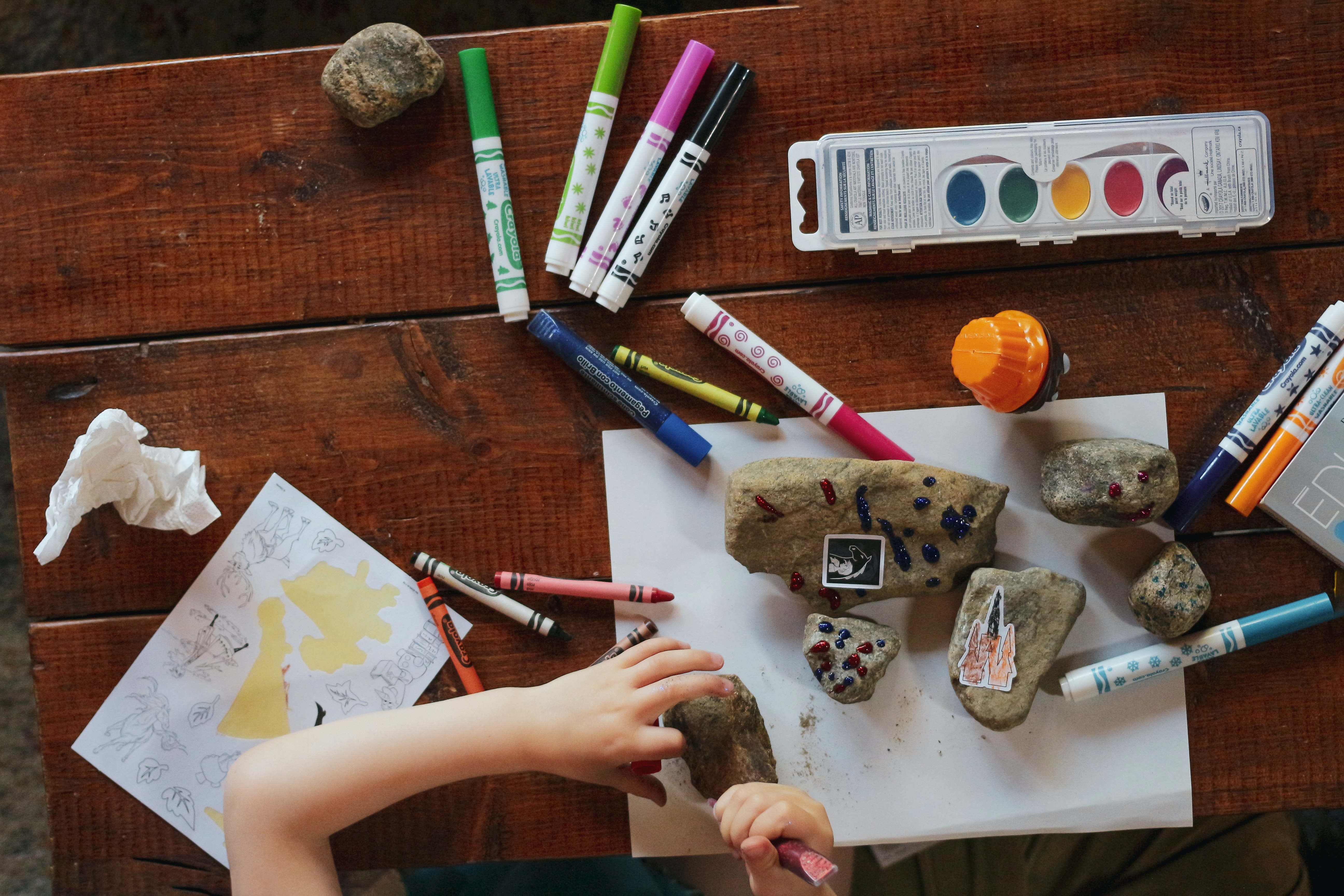 Child colouring and painting rocks